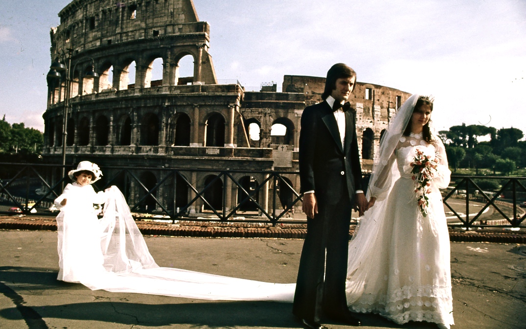 コロッセウム前での記念撮影１　Taking a ceremonial photograph in front of the Colosseum　長い花嫁のレースを女の子が一生懸命持っていた。今の私ならもっと上手に撮るけど、この写真は花婿が蝋人形みたいなところが奇妙である。　ⓒToshihiko Shibano